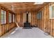 Cozy living room with wood paneled walls, a wood burning stove, and carpeted flooring at 2767 S Linley Ct, Denver, CO 80236