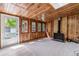 Cozy living room with wood paneled walls, a wood burning stove, and lots of windows at 2767 S Linley Ct, Denver, CO 80236