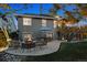 This backyard boasts a stone patio, outdoor seating, firepit, and a view of the deck and upper level at 12187 S Hidden Trail Ct, Parker, CO 80138