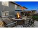 Backyard with stone patio, outdoor seating area, firepit, overhead deck with wood-burning lights at 12187 S Hidden Trail Ct, Parker, CO 80138