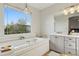 Bright bathroom with a soaking tub, vanity, and a large window that offers an outdoor view at 12187 S Hidden Trail Ct, Parker, CO 80138