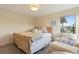 Bedroom includes a comfortable bed, a cozy armchair, and natural light at 12187 S Hidden Trail Ct, Parker, CO 80138