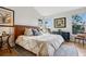 Bright bedroom featuring a leather headboard, large windows, and hardwood floors at 12187 S Hidden Trail Ct, Parker, CO 80138