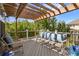 Outdoor deck with comfortable seating and overhead pergola with lighting at 12187 S Hidden Trail Ct, Parker, CO 80138