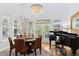 Elegant dining room featuring a chandelier, large windows, and a grand piano at 12187 S Hidden Trail Ct, Parker, CO 80138