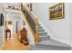 Bright entryway featuring a staircase with a dark metal railing and wood floors at 12187 S Hidden Trail Ct, Parker, CO 80138