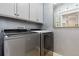 Laundry room equipped with a washer, dryer, cabinets and a decorative mirror at 12187 S Hidden Trail Ct, Parker, CO 80138