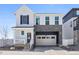 Charming two-story home with white siding, stone accents, a two-car garage, and a welcoming front porch at 1917 S Fultondale Way, Aurora, CO 80018