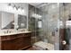 Luxurious bathroom with a double vanity and a walk-in shower with decorative tiles at 9009 Rambling Oak Pl, Parker, CO 80134