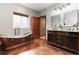 Stunning bathroom features a copper tub, double sink vanity and wood-look tile flooring at 9009 Rambling Oak Pl, Parker, CO 80134