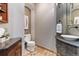 Stylish powder room with a decorative sink, modern faucet, granite countertop, and travertine flooring at 9009 Rambling Oak Pl, Parker, CO 80134