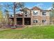 The back of the house has an outdoor deck, beautiful stone accents and lush landscaping at 9009 Rambling Oak Pl, Parker, CO 80134