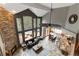 Open concept living area with stone fireplace, floor to ceiling windows, hardwood floors, and deck access at 9009 Rambling Oak Pl, Parker, CO 80134