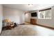 Finished basement living room with a rocking chair, TV, and a window at 9009 Rambling Oak Pl, Parker, CO 80134