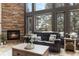 Cozy living room with a stone fireplace, large windows, and comfortable seating at 9009 Rambling Oak Pl, Parker, CO 80134