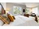 A main bedroom features an upholstered bed and large windows with a beautiful outdoor view at 9009 Rambling Oak Pl, Parker, CO 80134