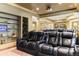 Basement home theater with tiered seating, a projector, sconces, and built in shelving at 9009 Rambling Oak Pl, Parker, CO 80134