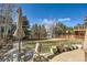 Well-maintained backyard with a patio set, lush green lawn, mature trees and a greenhouse at 25332 E Indore Dr, Aurora, CO 80016