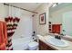 Bathroom featuring a shower-tub combo, vanity sink, and towel racks offering functionality and storage at 25332 E Indore Dr, Aurora, CO 80016