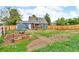 Large, fenced backyard featuring a garden, shed, and wooden patio, perfect for outdoor activities at 4694 S Ouray Way, Aurora, CO 80015