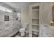 Modern bathroom featuring marble tile shower, vanity with marble countertop, and built-in shelving at 4694 S Ouray Way, Aurora, CO 80015