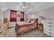 Bedroom with carpet, neutral walls, and a large window with red curtains providing natural light at 4694 S Ouray Way, Aurora, CO 80015