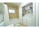 A combined bathroom/laundry room with a tub/shower and full-size washer and dryer, and folding closet doors at 15300 Cavanaugh Rd, Keenesburg, CO 80643