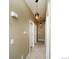 A long hallway with tan walls and flooring, lit by decorative pendant lights at 15300 Cavanaugh Rd, Keenesburg, CO 80643
