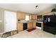 Functional kitchen with wooden cabinets, tile flooring, and black appliances providing modern convenience at 15300 Cavanaugh Rd, Keenesburg, CO 80643