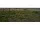 Vast, grassy property with distant fences and structures under a clear sky at 15300 Cavanaugh Rd, Keenesburg, CO 80643