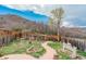 Fenced backyard with lush landscaping, stone pathway, and tranquil setting at 1552 Live Oak Rd, Castle Rock, CO 80104