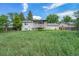 View of a house backyard with a covered deck overlooking an expansive yard, offering potential for outdoor enjoyment at 757 Norfolk Way, Aurora, CO 80011