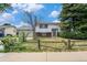 Charming home with a yard featuring a rustic fence and mature trees under a bright sky at 757 Norfolk Way, Aurora, CO 80011