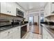 Modern kitchen with white cabinets, black appliances, and granite countertops at 9725 E Harvard Ave # 349, Denver, CO 80231