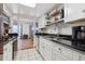 Modern kitchen with white cabinets, black appliances, and granite countertops at 9725 E Harvard Ave # 349, Denver, CO 80231