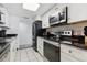 Modern kitchen with white cabinets, black appliances, and granite countertops at 9725 E Harvard Ave # 349, Denver, CO 80231