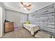 Charming bedroom showcasing a ceiling fan, rustic accent wall, and ample natural light at 10289 Dresden St, Firestone, CO 80504