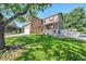 A beautiful two-story home with a large, green lawn and mature trees at 10289 Dresden St, Firestone, CO 80504