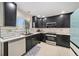 Charming kitchen showcasing sleek black cabinets, stainless appliances, and bright white tile backsplash at 10289 Dresden St, Firestone, CO 80504