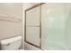 Small bathroom features tile walls and a bathtub with an ornate glass shower door at 16261 W Ellsworth Ave, Golden, CO 80401