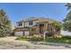 Charming two-story brick home with a well-manicured front yard and a two-car garage during the daytime at 16261 W Ellsworth Ave, Golden, CO 80401