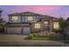 Charming two-story brick home with a well-manicured front yard and a two-car garage at dusk at 16261 W Ellsworth Ave, Golden, CO 80401