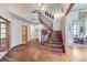 Spacious foyer with hardwood floors, a staircase with wood banister, and chandelier at 16261 W Ellsworth Ave, Golden, CO 80401