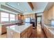 Open kitchen features a stone countertop island, wood floors, and ample cabinets at 16261 W Ellsworth Ave, Golden, CO 80401