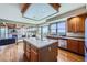 Open-concept kitchen with a center island, stainless steel appliances, and panoramic windows at 16261 W Ellsworth Ave, Golden, CO 80401