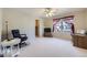 Bright living room featuring a ceiling fan, neutral carpet, and large windows providing natural light at 16261 W Ellsworth Ave, Golden, CO 80401
