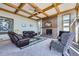 Cozy living room with a brick fireplace, wood-coffered ceiling, comfortable seating, and a large window at 16261 W Ellsworth Ave, Golden, CO 80401