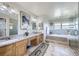 Main bathroom features dual sinks, granite countertops, a soaking tub, and glass shower at 16261 W Ellsworth Ave, Golden, CO 80401