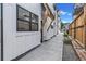 Townhouse exteriors feature black framed windows, a covered entry, a smooth concrete walkway, and wood fence at 3219 W 19Th Ave # 4, Denver, CO 80204
