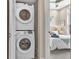 Convenient in-unit stacked washer and dryer setup next to a bedroom featuring a modern ceiling fan at 3219 W 19Th Ave # 4, Denver, CO 80204